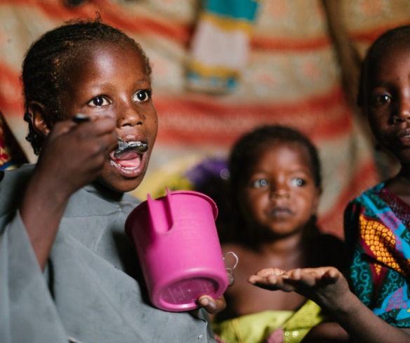 Saide’s children inside the family’s tent. Each day, they receive a nutritious meal cooked by the Porridge Moms.