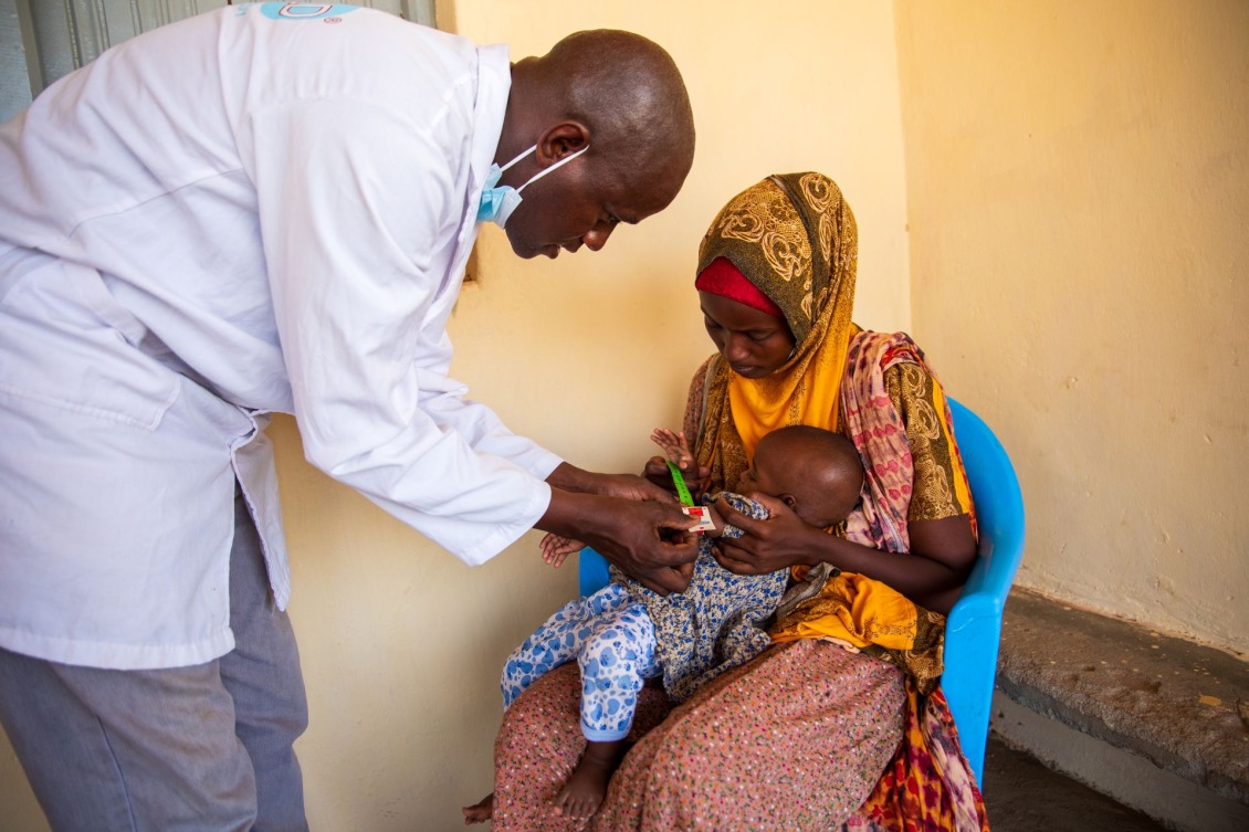 A doctor screening a child for malnutrition in Kenya.