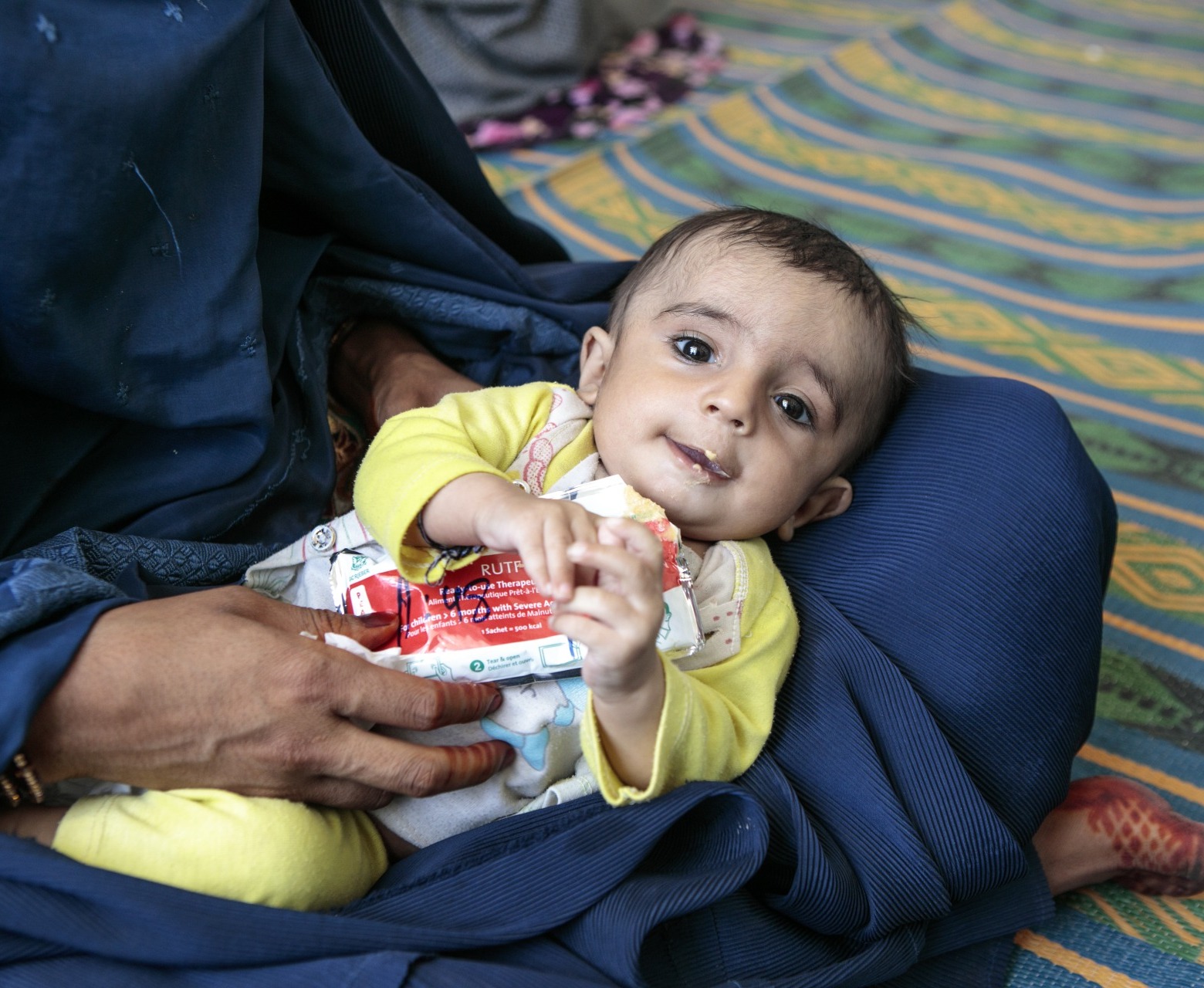 A child eats Plumpy'Nut, a peanut paste used to treat malnutrition.
