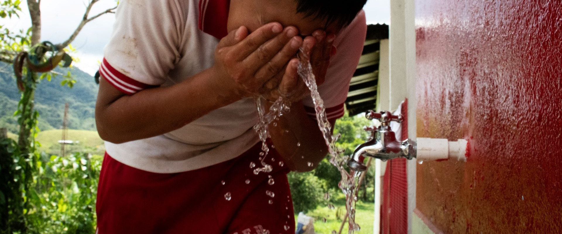 A child washing his face in Colombia.