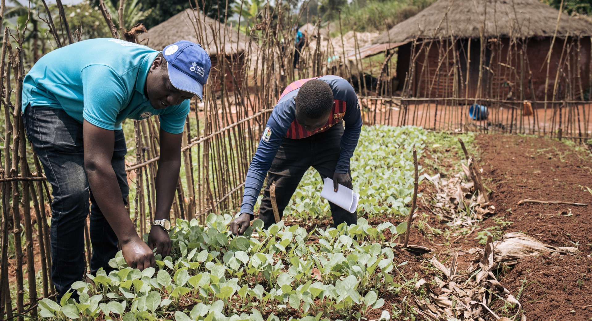 An Action Against Hunger aid workers teaches a farmer skills to help his crops grow.