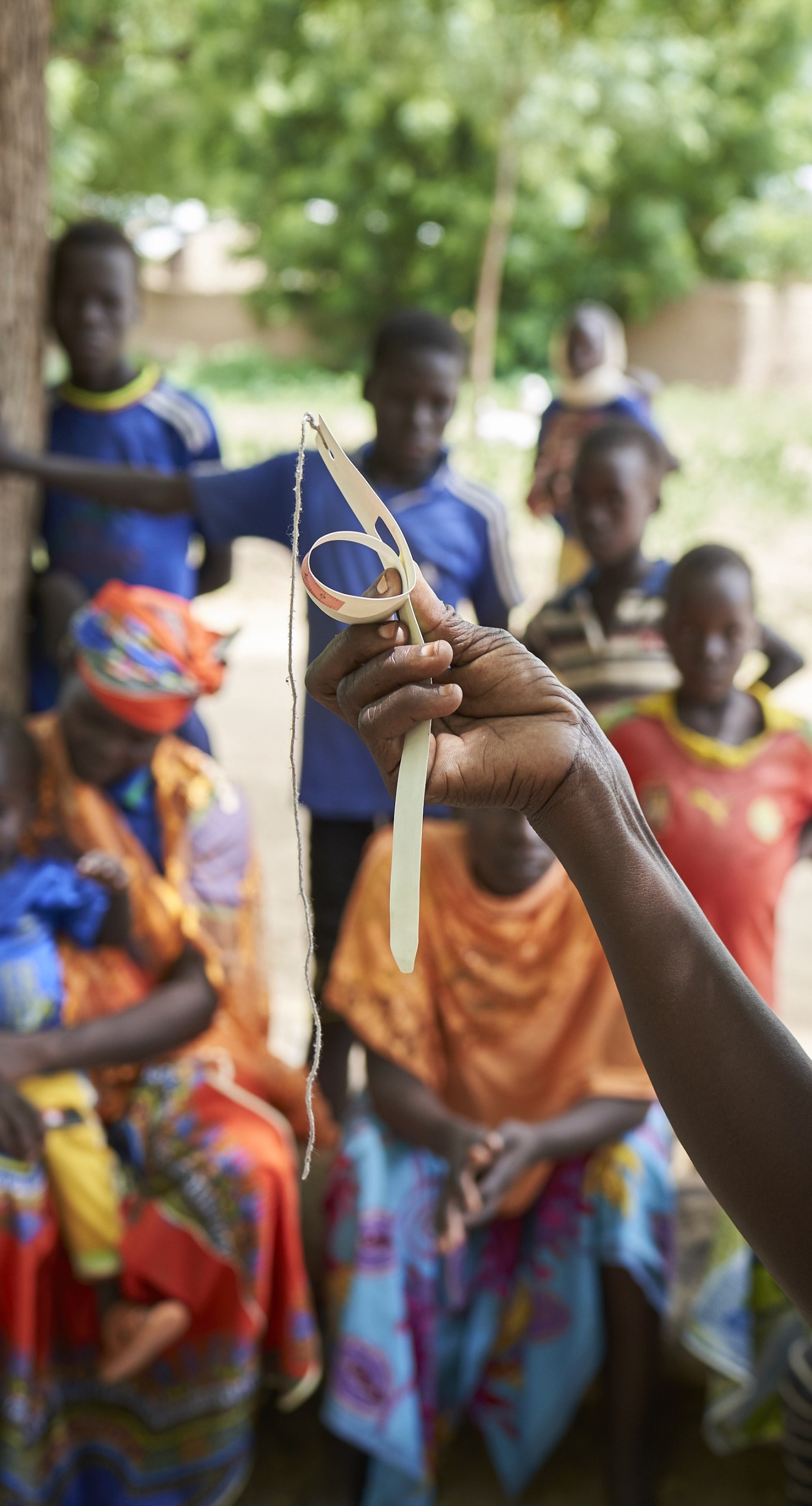 At a community training, a member of our team trains parents how to use a color-coded measuring band to check their children's nutrition status.
