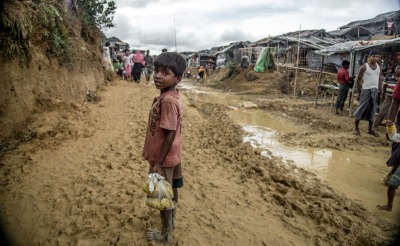 Young boy leaving Action Against Hunger food distribution to Rohingya refugees in Balukhali settlement, Cox's Bazar, Bangladesh. Photo: Kathleen Prior for Action Against Hunger, Bangladesh