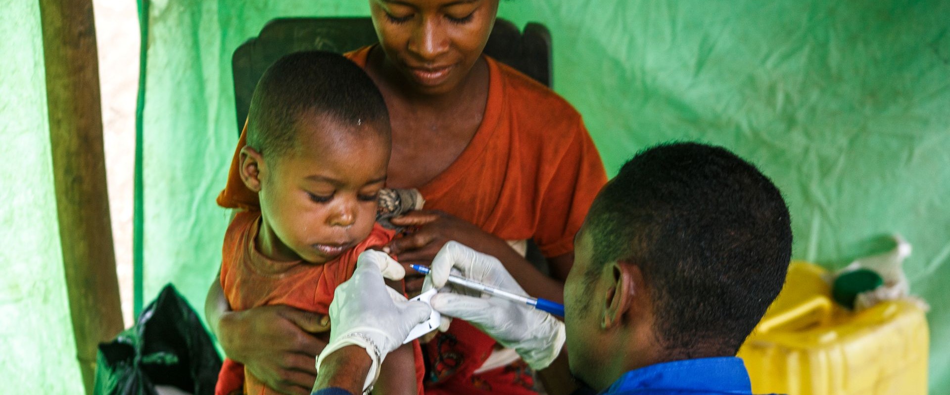 In Madagascar, an Action Against Hunger staff member uses a Mid-Upper Arm Circumference (MUAC) band to check a child for malnutrition.