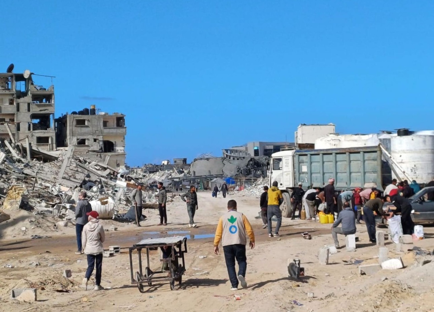 Action Against Hunger aid worker walking amidst rubble in Gaza in January 2025.