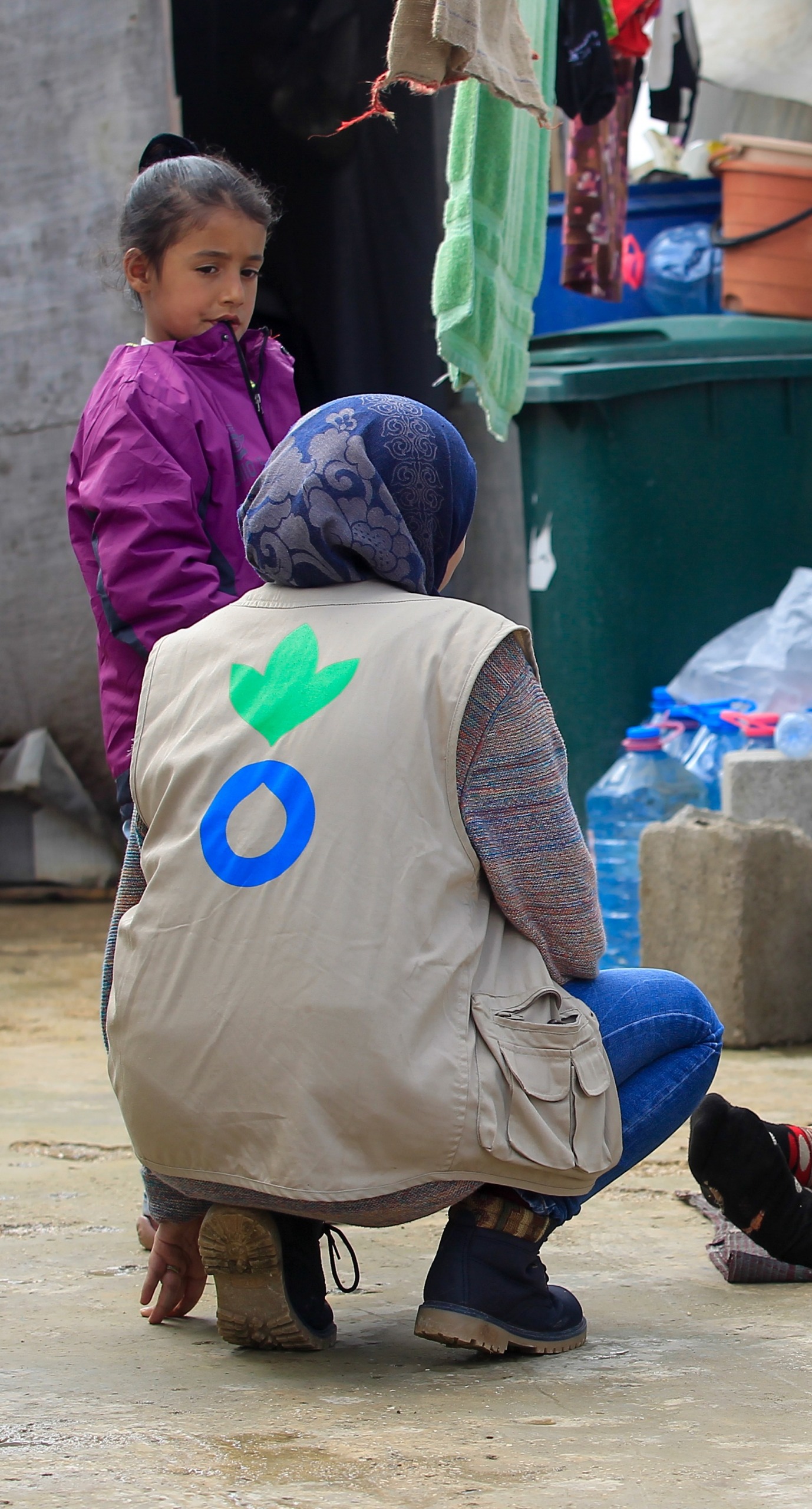 An Action Against Hunger aid worker talks with a refugee family in Lebanon.