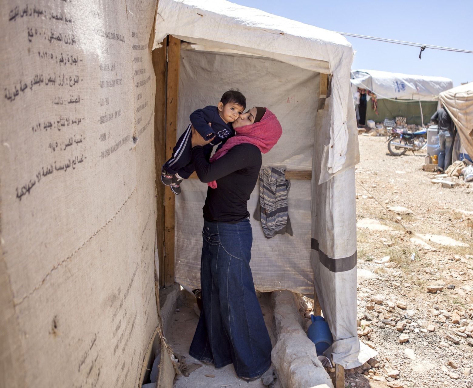 A Syrian refugee kisses her son.