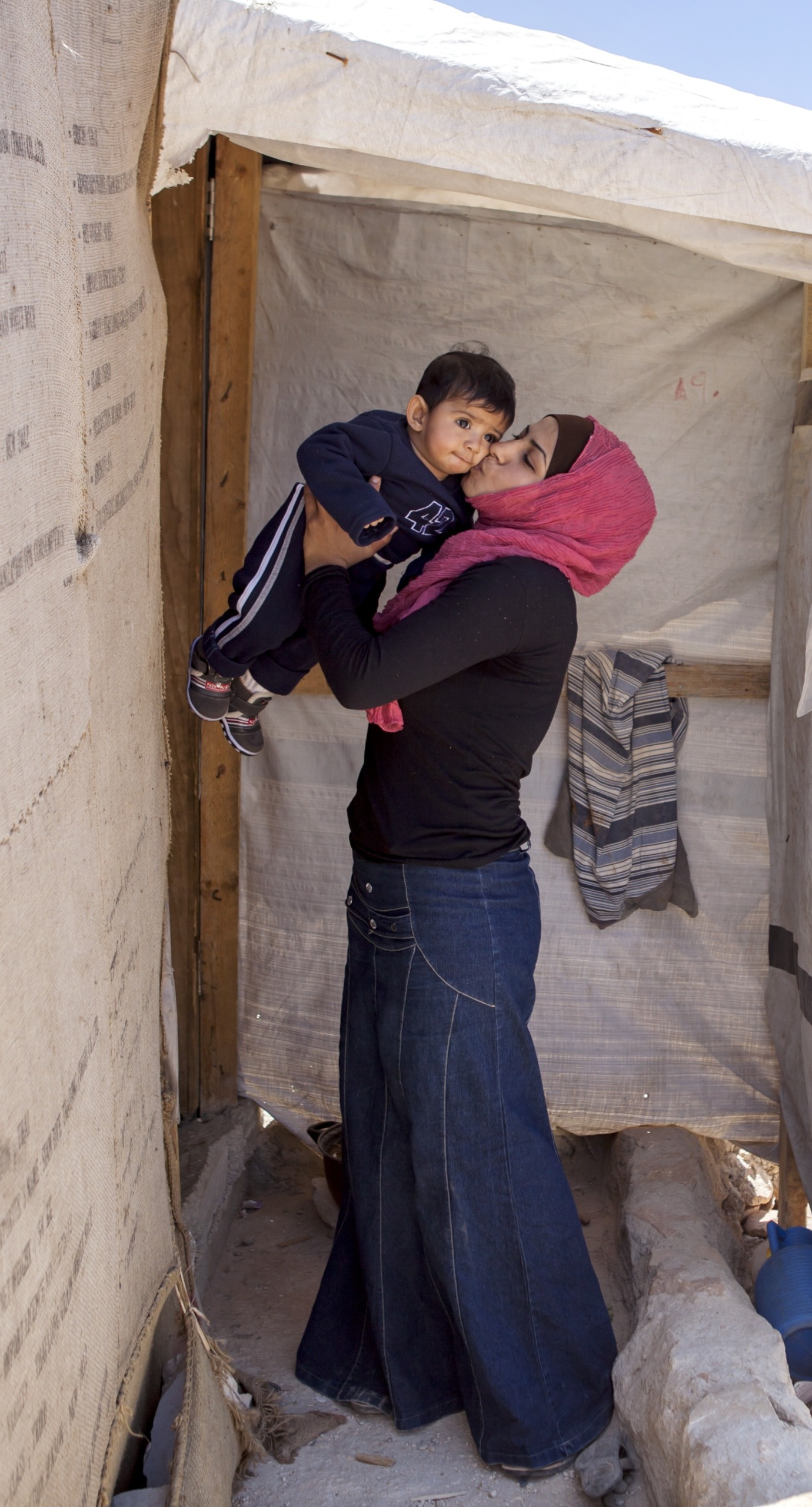 A Syrian refugee kisses her son.