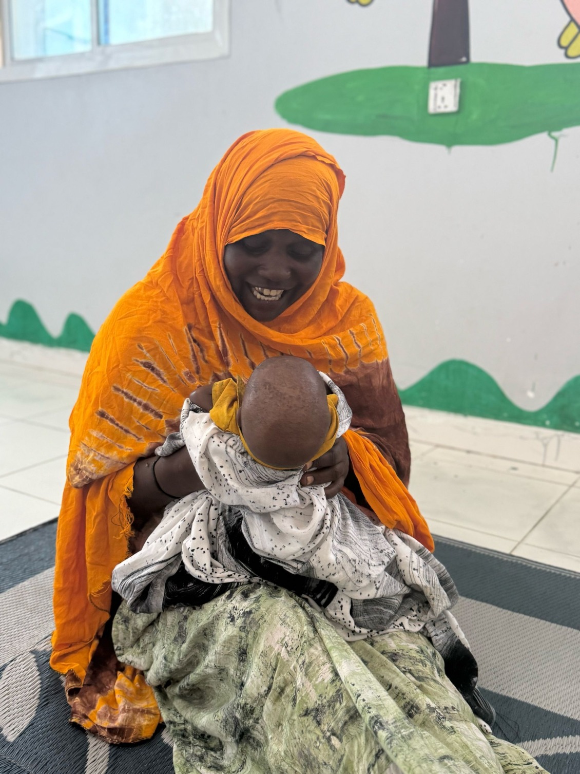 Maria plays with her grandson at the stabilization center in Mogadishu