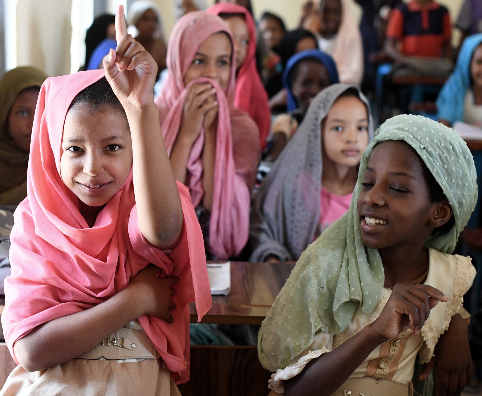 A girl raising her hand in school in Mauritania.