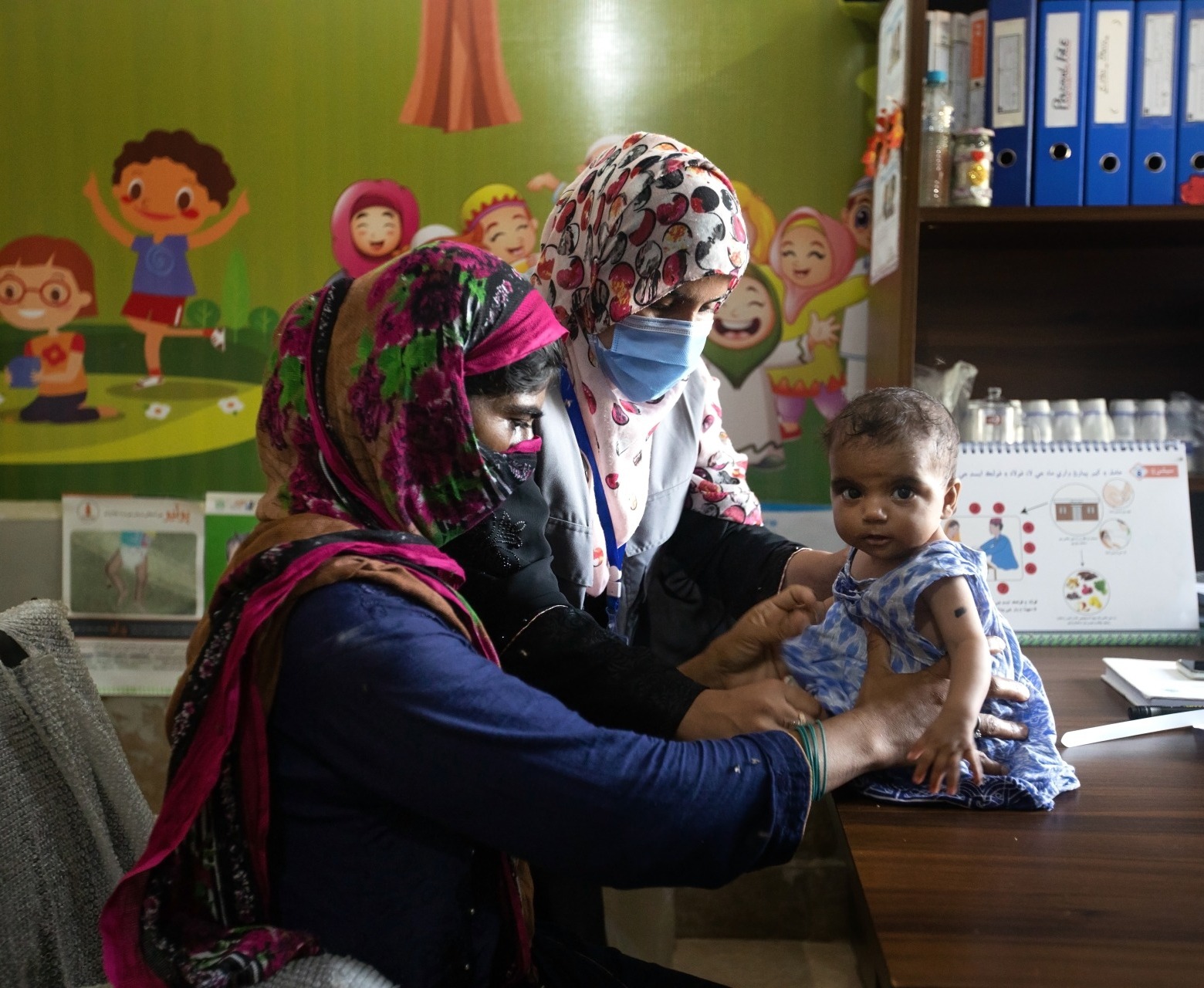 Dr. Zarina Lashari, a nutrition assistant, consults with a mother and child at an outpatient treatment center in Sindh, Pakistan.