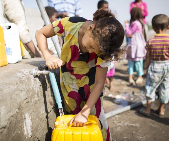 A girl gets water from a tap in Yemen.