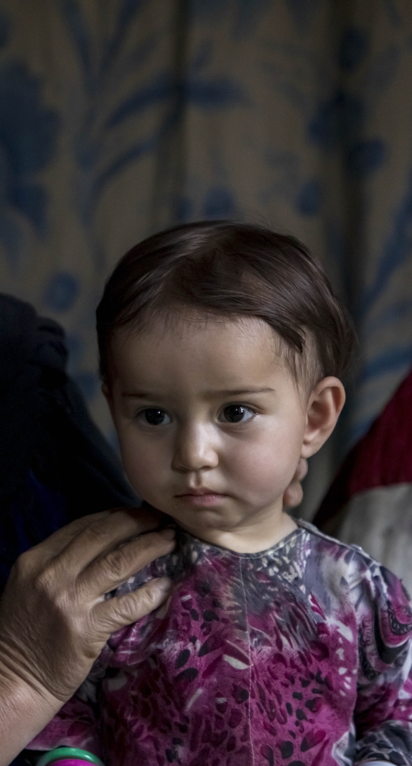 Mahnaz holds her youngest daughter, 13-month-old Maimana, in their home in Duykondi Province, Afghanistan. Action Against Hunger works in this area to manage feeding programs and provide mobile health and nutrition support.