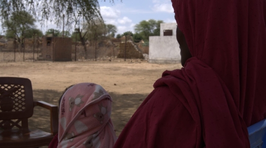 A 30-year-old mother and farmer receives RUTF for her child from a health facility.