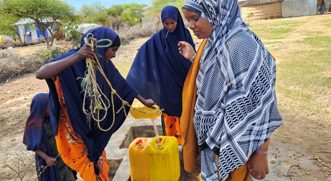 Three women fetch water from a well in Somalia.