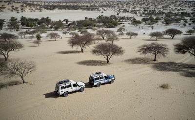 Action Against Hunger trucks drive through a desert in the Sahel region of West Africa.