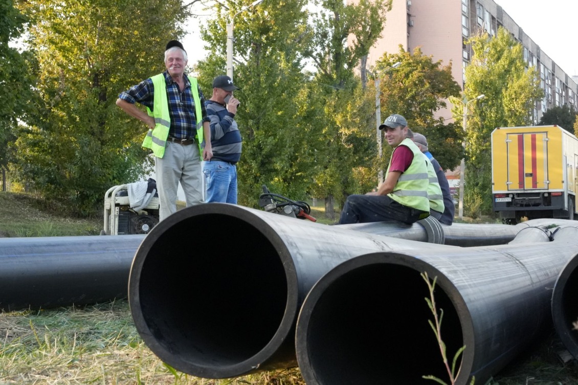 Water utility workers and polyethylene pipes provided by Action Against Hunger.