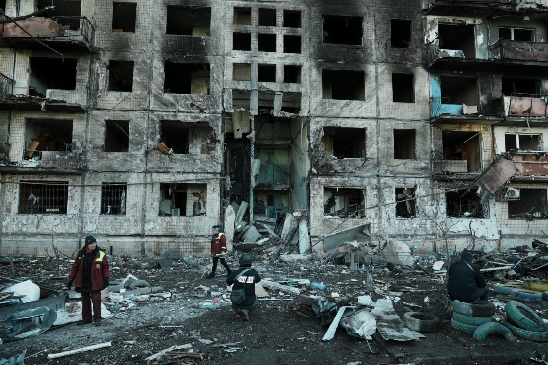 Firefighters rescue civilians from a damaged building.