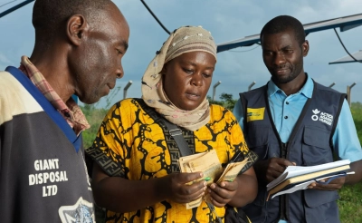 Action Against Hunger staff member works with a Ugandan woman.