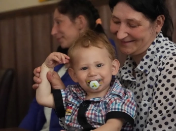 A woman holds a baby with a binky in his mouth in Dnipro, Ukraine.